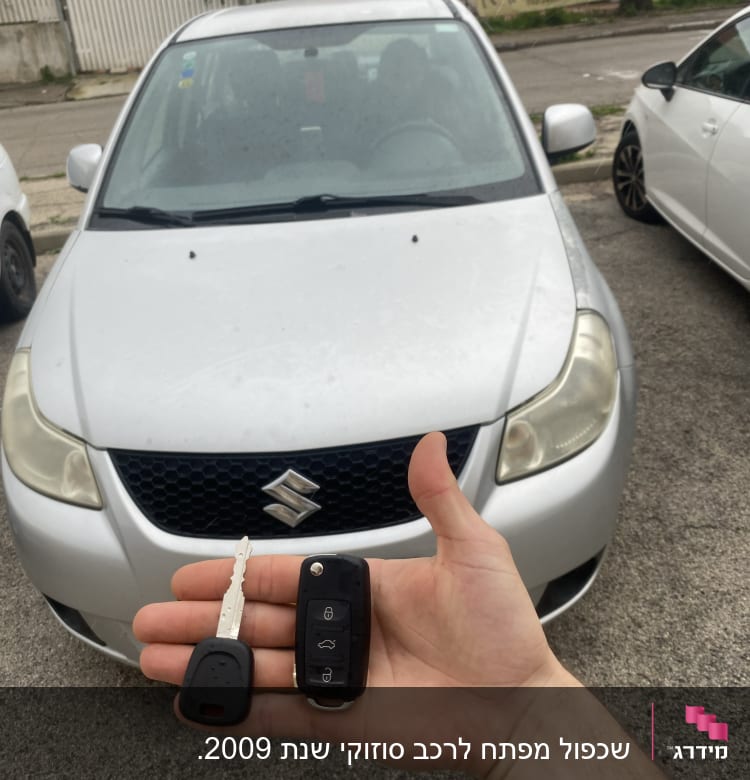 מפתח ושלט לרכב מוחזקים מול רכב סוזוקי כסוף